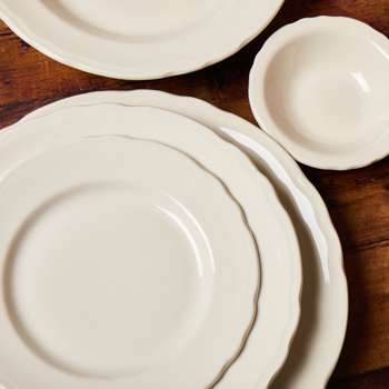 Set of white ceramic plates on a wooden surface