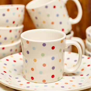 Polka dot ceramic cups and saucers on a wooden surface