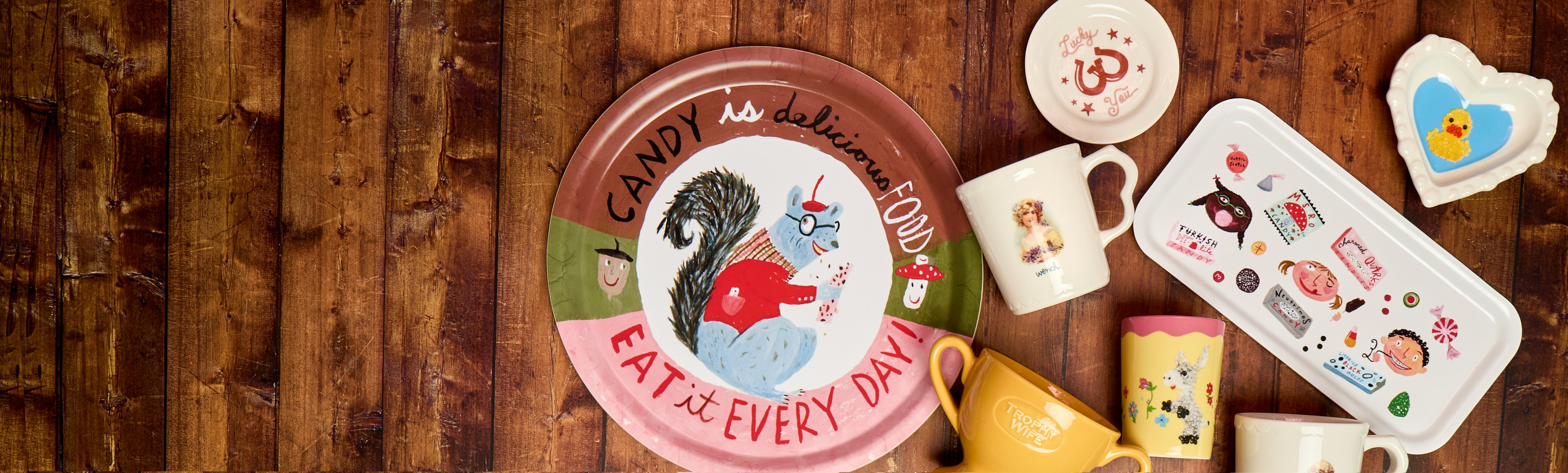 Collection of ceramic items with animal illustrations on a wooden surface