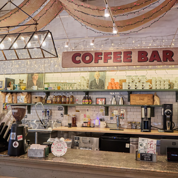 Coffee bar with shelves stocked with various items and a prominent 'COFFEE BAR' sign.