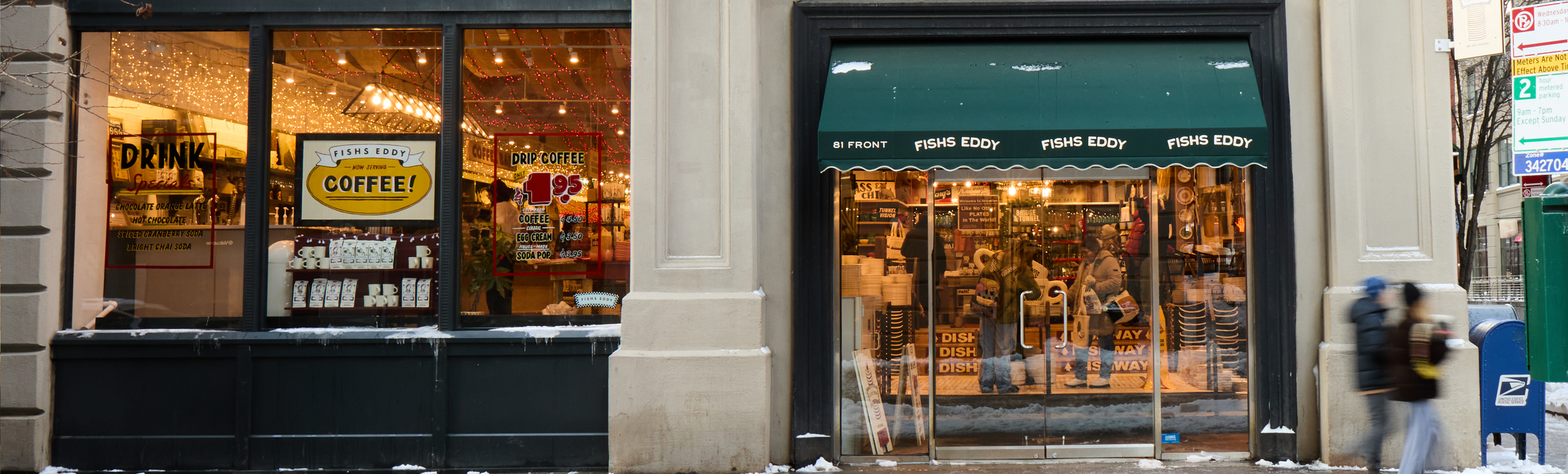 Storefront with large windows displaying products and a person walking by.