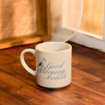 White mug with 'Good Morning Isshie' text on a wooden surface