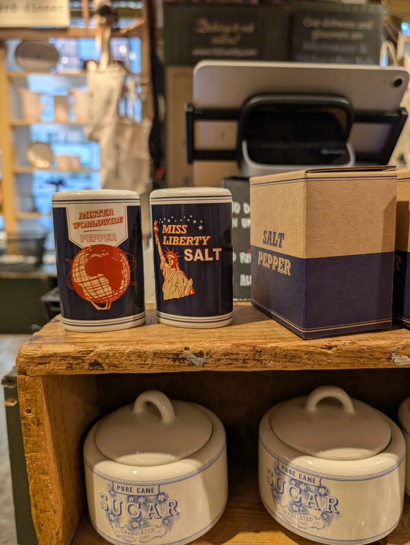NYC icons salt and pepper shakers beside their gift box on a wooden shelf